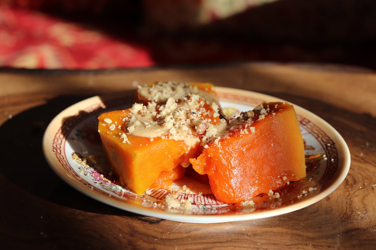 Close-up of a traditional pumpkin dessert topped with crushed nuts on a decorative plate.